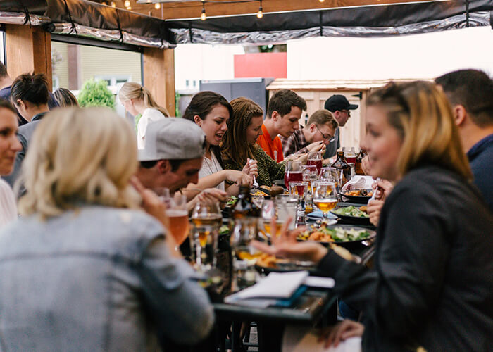 Pessoas alegres almoçando em restaurante lotado